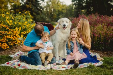 A family poses with their dog at the CSU Trial Gardens in Fort Collins