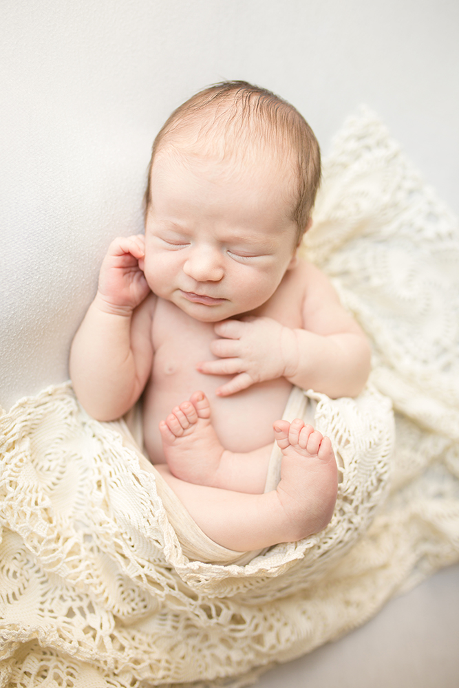 Simple natural newborn photo taken in baby's Fort Collins home with a lace wrap