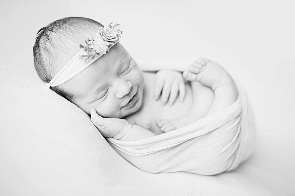 Black and white photo of a smiling baby girl taken by Becky Michaud, Fort Collins newborn photographer