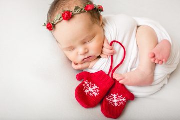 Newborn photo of a baby with red mittens and a red flower crown taken by Becky Michaud, Fort Collins photographer