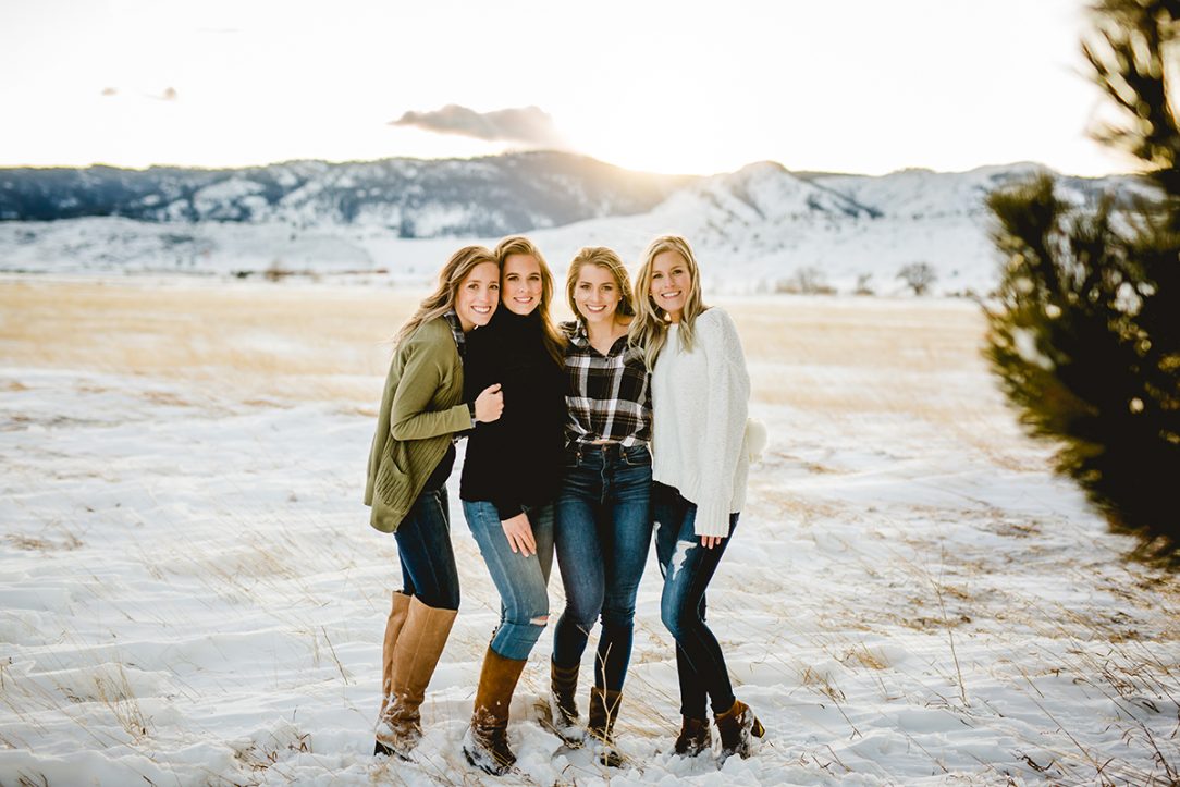 Four grown sisters stand together for their family portrait near the foothills of Fort Collins, Colorado