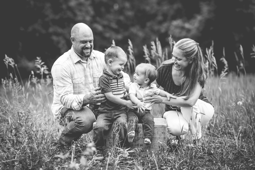 a family of four laughs together during their photo session at a Fort Collins natural area