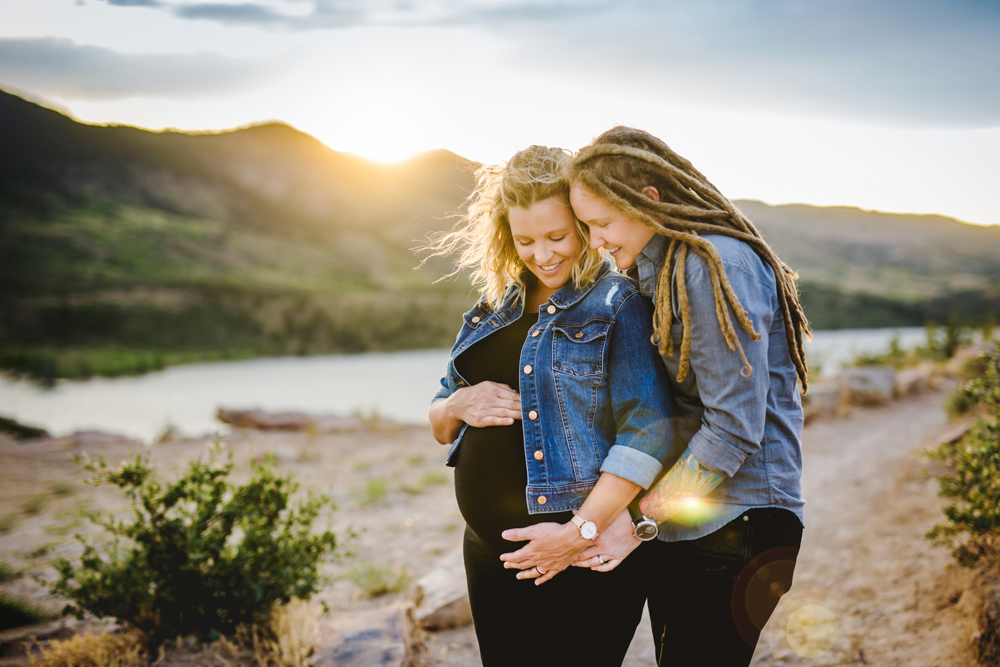 A couple poses at the top of Horsetooth Reservoir in Fort Collins during their maternity photography session