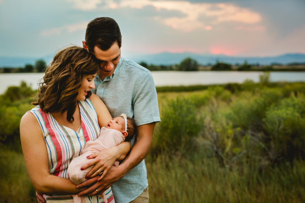 New parents admire their newborn baby girl during their family photo session
