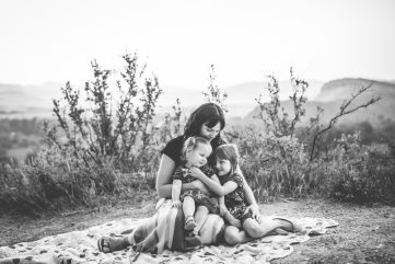 Black and white photo of a mom snuggling with her two girls taken by Becky Michaud, Fort Collins family photographer