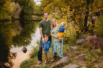 A family poses by the Poudre River in the fall