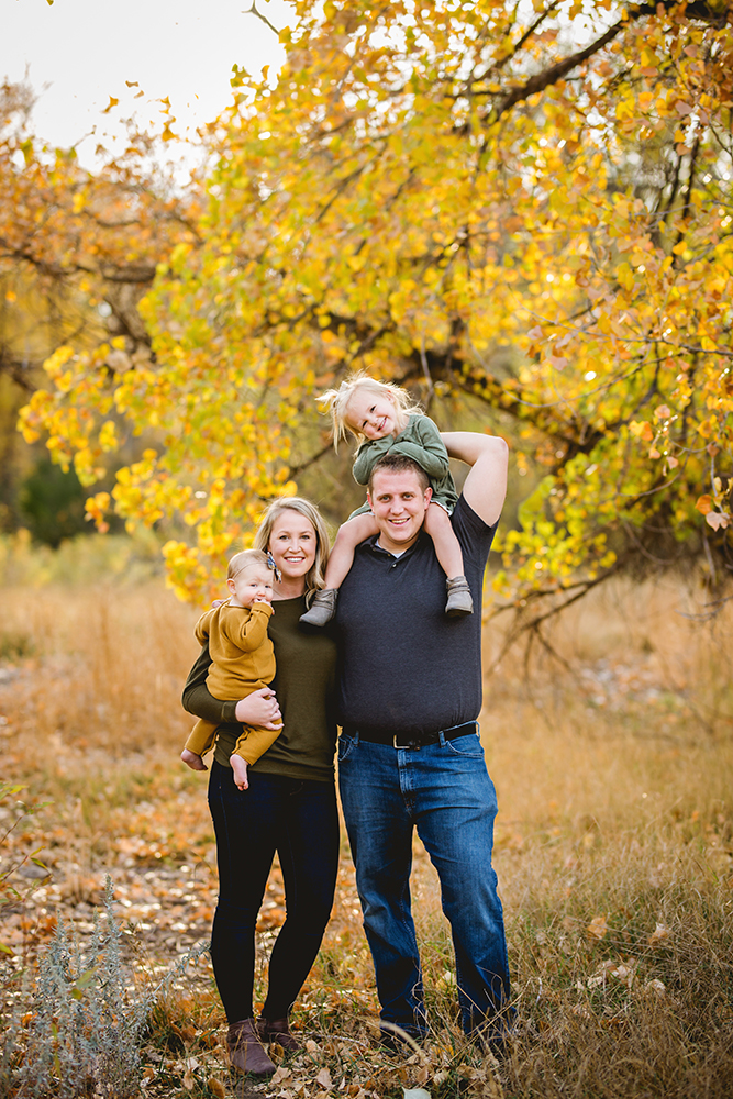 Family portrait of a family of four with two little girls in the fall in Colorado