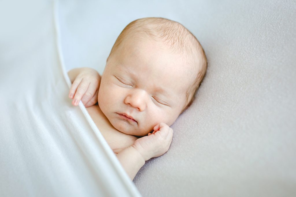Sweet newborn photo of a sleeping baby tucked in under a blanket in Denver, Colorado