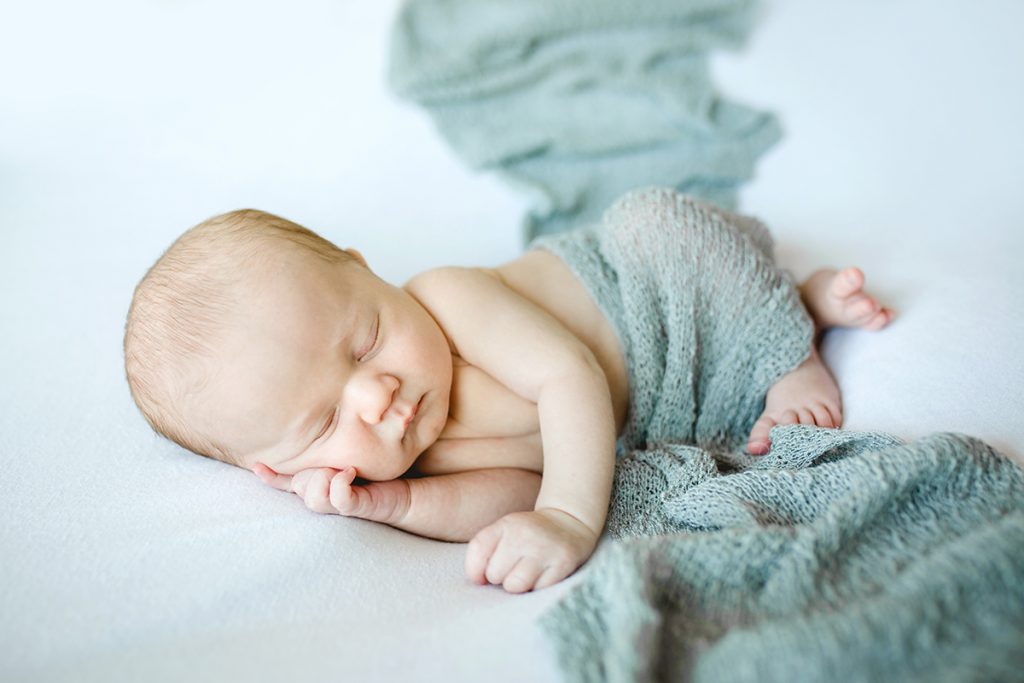 Simple, timeless newborn photo in neutral colors taken in baby's home in Colorado