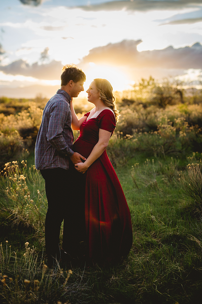 Pregnancy photo of a couple in golden light at a lake in Loveland, Colorado