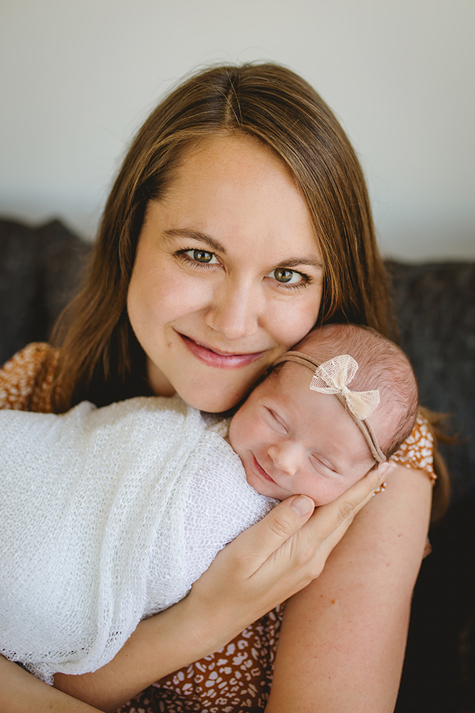 A new mom holds her baby in a newborn photo taken by Becky Michaud, Fort Collins newborn photographer