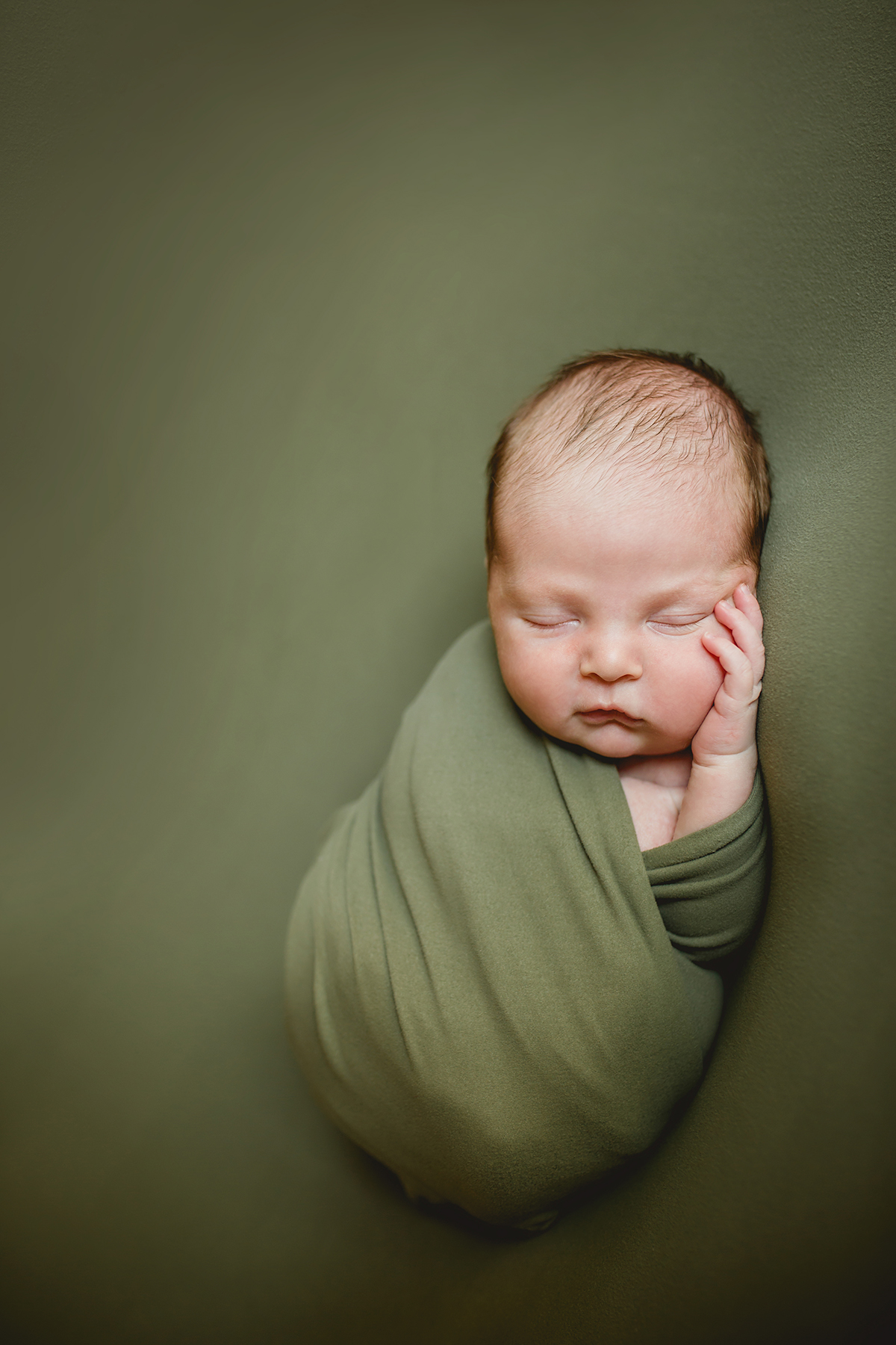 Newborn photo of a baby boy on green taken by Becky Michaud, Fort Collins newborn photographer