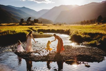 A family plays in the creek during their photography session at Rocky Mountain National Park