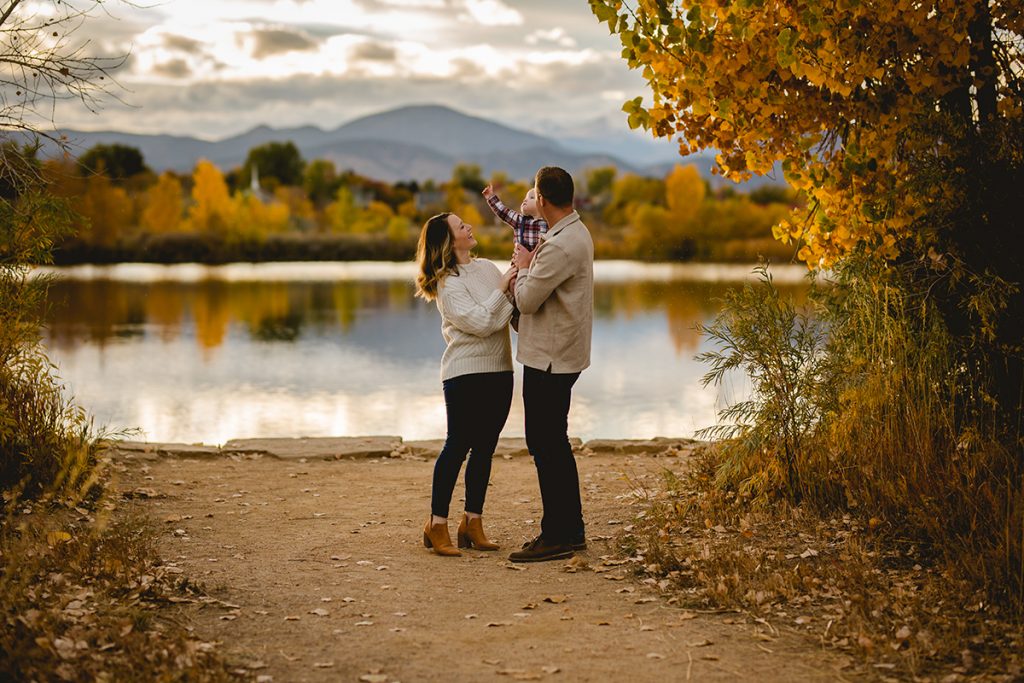 Family photo shoot by a lake with mountains in the background in Loveland, Colorado