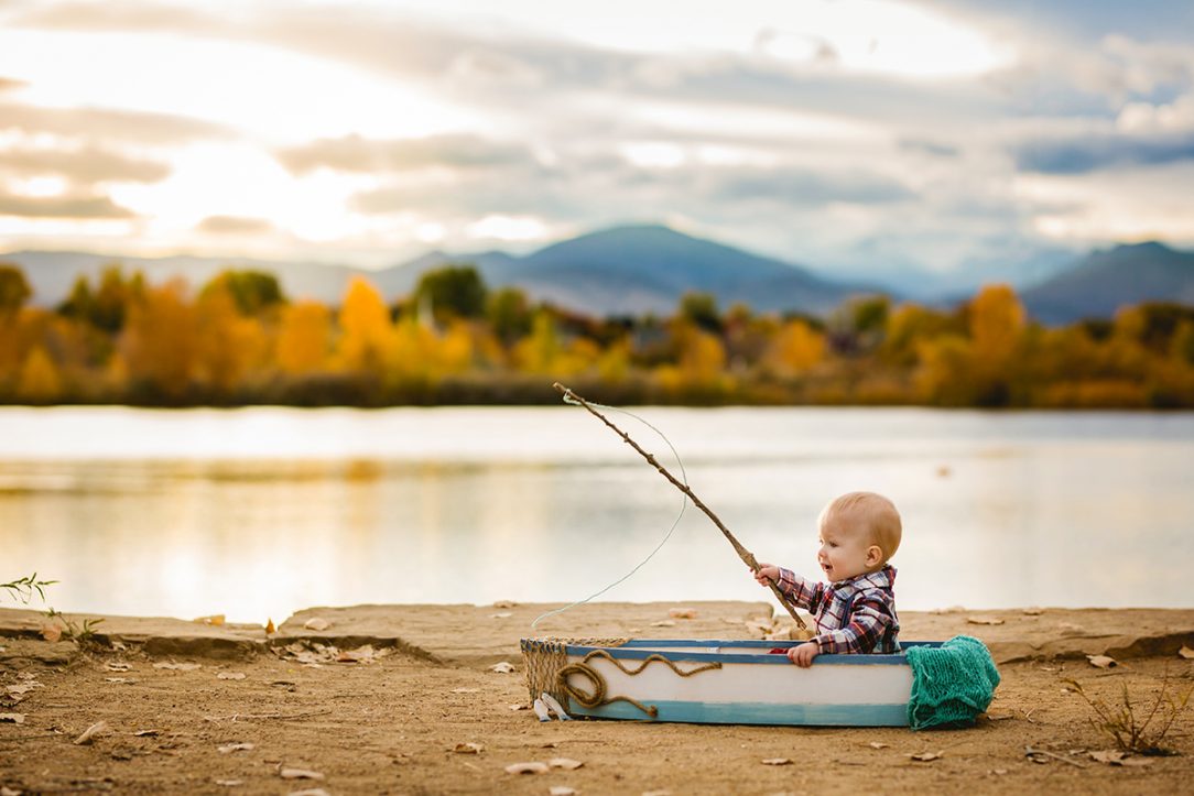 Fishing themed one year photo session by a lake in Loveland Colorado