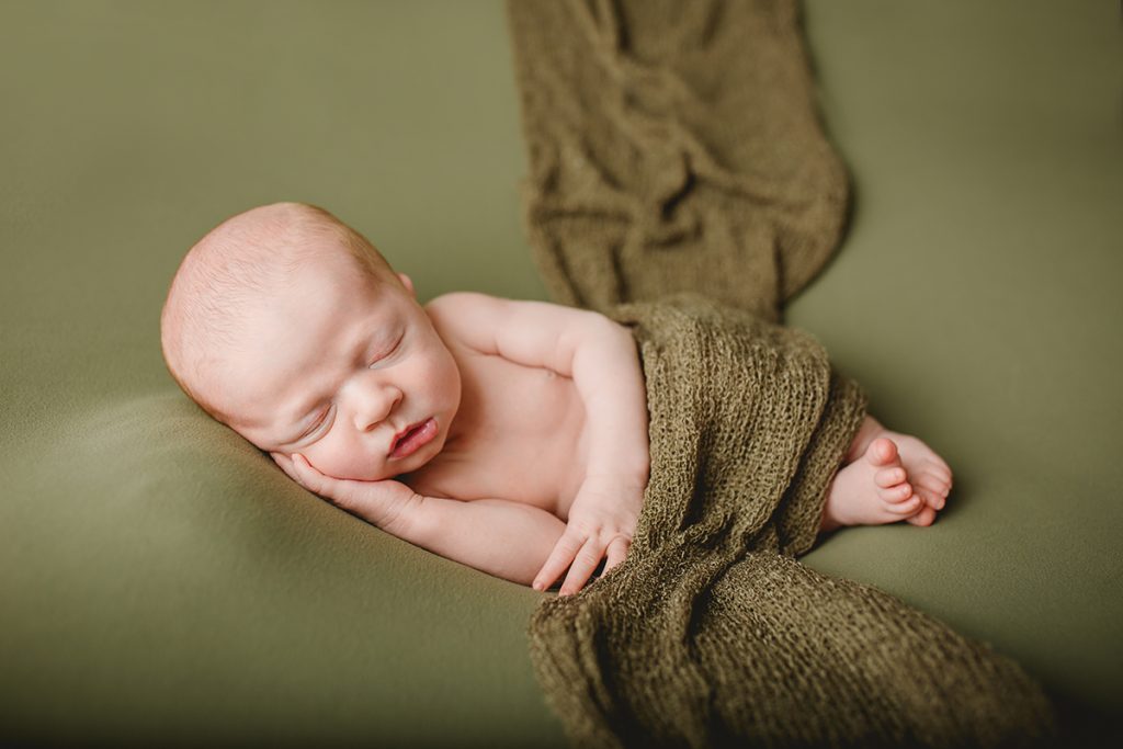 Newborn photo of baby on green witha  green blanket, taken by Becky Michaud, Fort Collins newborn photographer