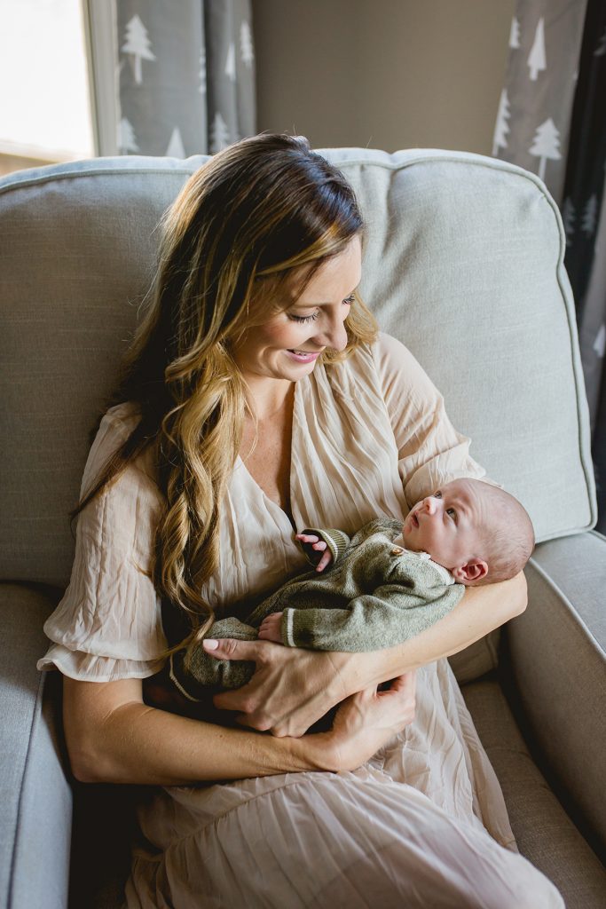 Newborn lifestyle photo in Loveland Colorado of mom holding her baby in his nursery