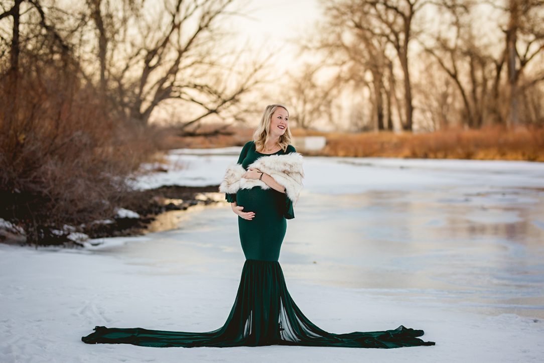 Maternity photo of a mom wearing hunter green chicaboo monroe dress with a faux fur wrap