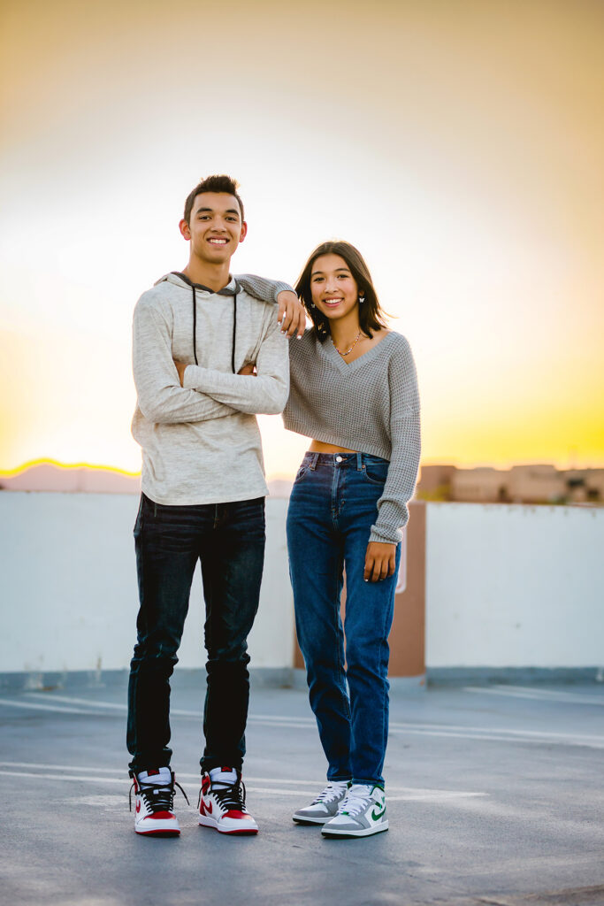 Two teens pose on top of a parking garage for their photo shoot in Old Town Fort Collins